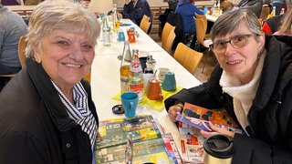 Viele fröhliche Gesichter in der Karlsruher Vesperkirche. Sie kommen für die warmen Mahlzeiten und die Gemeinschaft.