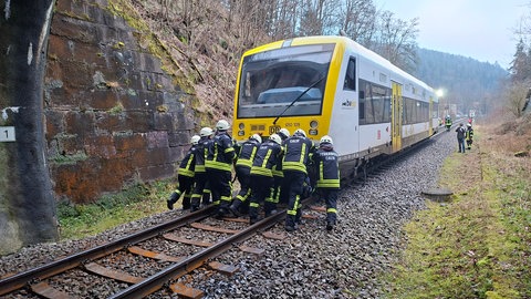 Zug und Feuerwehrmänner auf den Bahngleisen bei Calw.