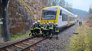Zug und Feuerwehrmänner auf den Bahngleisen bei Calw.