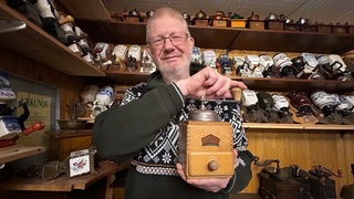 Sammler Günter Fiebelkorn aus Bretten mit seiner allerersten Kaffeemühle in der Hand