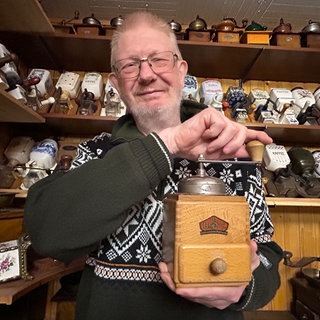 Sammler Günter Fiebelkorn aus Bretten mit seiner allerersten Kaffeemühle in der Hand