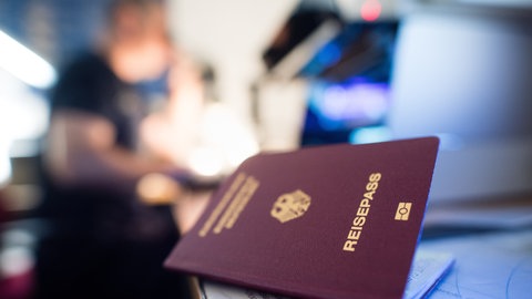 (Symbolbild) Reisepass liegt bei einer Kontrolle am Flughafen auf einem Tisch.