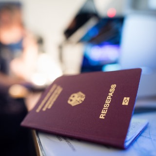 (Symbolbild) Reisepass liegt bei einer Kontrolle am Flughafen auf einem Tisch.