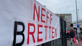 Menschen mit Plakaten bei einer Protestaktion am NEFF-Werk in Bretten.