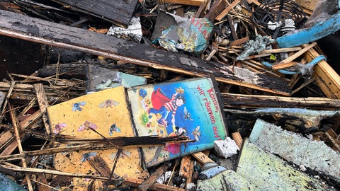 Zerstörte Kita nach Brand in Durmersheim - kaputte Kinderbücher liegen auf dem Boden.