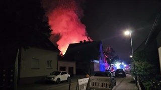 Flammen steigen in den Nachthimmel von Eggenstein-Leopoldshafen (Kreis Karlsruhe. In der Nacht auf Donnerstag hat ein Feuer eine Scheune und ein Wohngebäude erfasst.