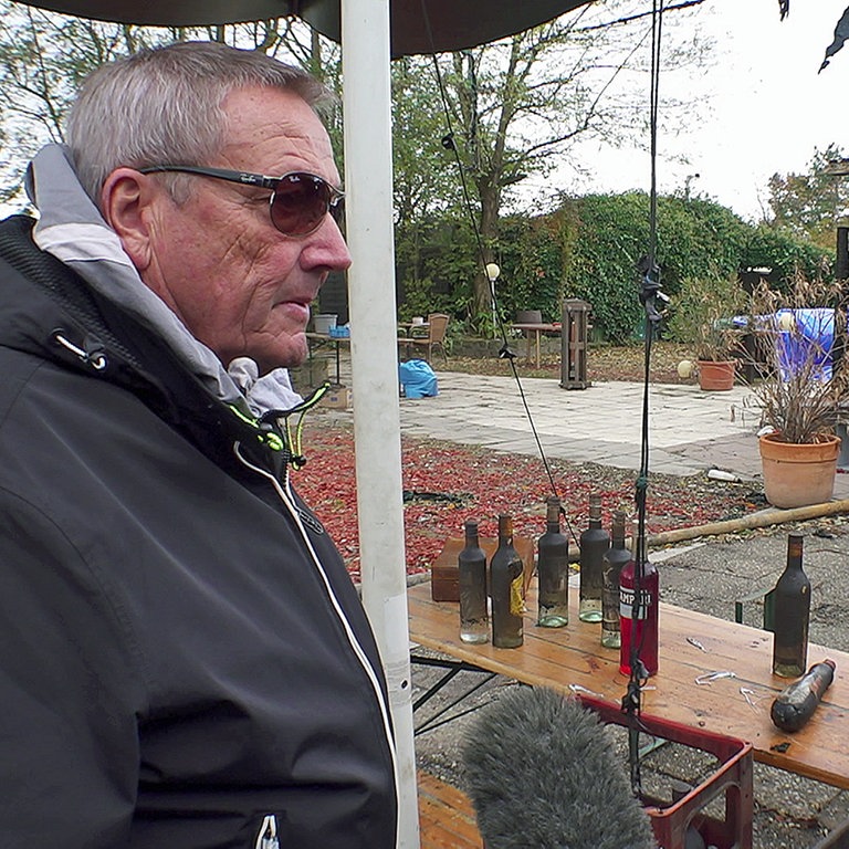 Einige verrußte Getränkeflaschen haben die Flammen im Biergarten "Seegugger" am Epplesee überlebt. Der Besitzer schaut auf sein zerstörtes Lebenswerk.