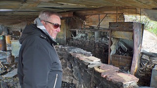 Gastronom Harald Sieder steht einem Monat nach dem Brand in den zerstörten Überresten seines "Restaurant" Seegugger in Rheinstetten.