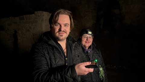 Buchautor und Filmemacher Eric Hordes und Medium Madame Beatrice aus Baden-Baden, er hält einen Magnetfeld-Detektor in der Hand