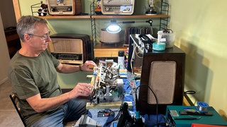 Musiktruhen-Retter Peter Keßner aus Bischweier beim Reparieren vor einem geöffnetem Radio.