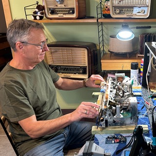 Musiktruhen-Retter Peter Keßner aus Bischweier beim Reparieren vor einem geöffnetem Radio.