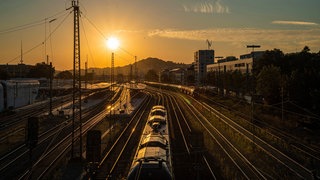 Die Bahnhof in Pforzheim von oben bei Sonnenuntergang. Blick auf die Gleise und einen Zug.