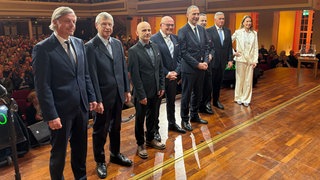 Die acht Kandidierenden für das Amt des Oberbürgermeisters in Baden-Baden auf der Kurhausbühne