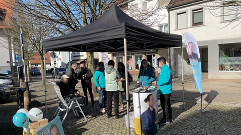 Wahlkampfstand mit Zelt neben Wochenmarkt in Östringen