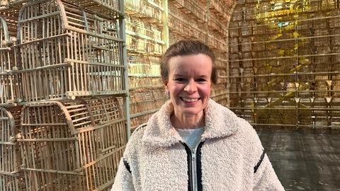Die Pfarrerin der Stadtkirche Claudia Rauch steht vor der Kunstinstallation "The Cage" in Karlsruhe".