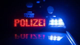 Zwei Polizisten stehen vor einem Polizeifahrzeug (Symbolbild): Bei Rheinau sind bei einem Unfall vier Menschen schwer verletzt worden