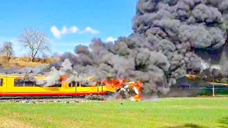 Ein Lkw kollidiert an einem unbeschrankten Bahnübergang mit einer Straßenbahn, beide Fahrzeuge stehen in Flammen.
