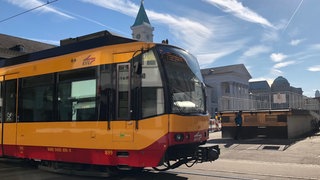 Gelbe Stadtbahn fährt am Karlsruher Marktplatz vorbei