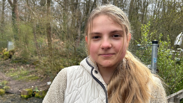 Ein Mädchen steht vor Ostern vor einem Gehege im Wildpark Pforzheim.