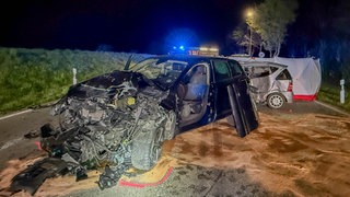 Zwei Autos mit großem Schaden stehen auf einer Straße. Bei dem Unfall kam eine 22-Jährige ums Leben, ein 59-Jähriger wurde schwer verletzt.