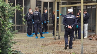 Polizisten stehen vor dem ehemaligen Mauritius-Restaurant in der Nähe des Karlsruher Bahnhofsvorplatzes. Dort wurde eine Leiche gefunden.
