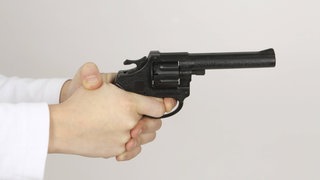 (Symbolbild) Hände an einer Spielzeugpistole - ein Mann hat in Gaggenau einen größeren Polizeieinsatz ausgelöst, weil er mit Spielzeugpistolen unterwegs war.