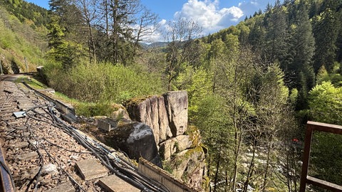 Schienen vor einem Abhang bei Forbach sind beschädigt, hier ist ein Bagger bei Gleisarbeiten abgestürzt.