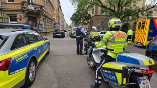 Ein Mann hat sich in der Karlsruher Südstadt in einer Wohnung verschanzt. Es stehen mehrere Einsatzgfahrzeuge an der Straße.