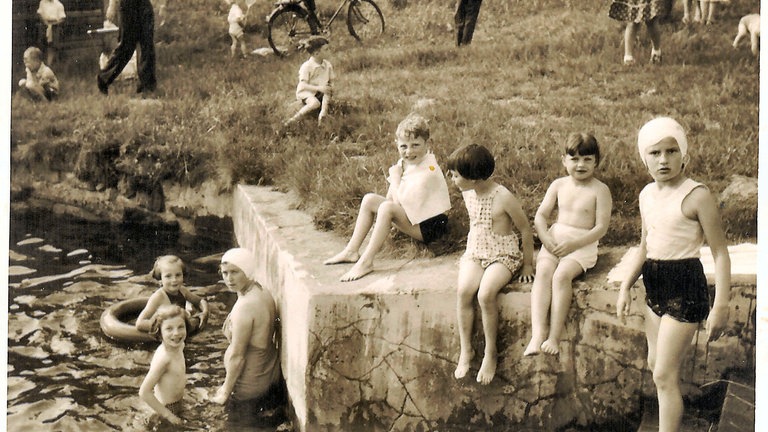 Besucherinnen und Besucher schwimmen im Freibad Lautenbach. Das Freibad steht im Rahmen des Zukunftspakets 2030 der Stadt Gernsbach auf der Kippe.