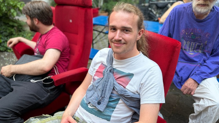Besucher Alexander macht nach dem Abschrauben eine Sitzprobe im alten Kinosessel der Schauburg.