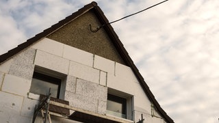 (Symbolbild) Ein Haus aus den 1930er-Jahren wird mit Styroporplatten auf der Außenwand gedämmt. Eine Plattform aus Karlsruhe soll die Planug von energetischen Sanierungen vereinfachen.
