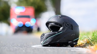 Symbolbild: Ein Motorradhelm liegt auf einer Straße.