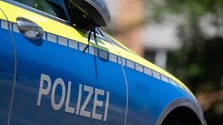Ein Polizeiauto steht an einer Straße. Nachdem es im Enzkreis rund 40 Brände in drei Monaten gegeben hat, ist nun ein Tatverdächtiger in Haft.