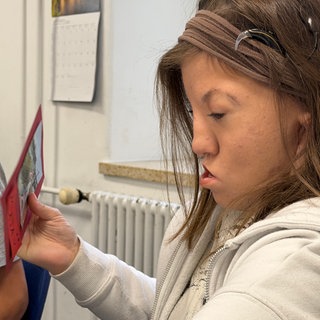 Maja macht ihre Deutschaufgaben. Sie ist schwerhörig und lernt an einem SBBZ.