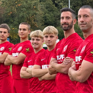 Sechs Zwillinge stehen in roten Trikots auf einem Fußballfeld des SV Bühlertal.