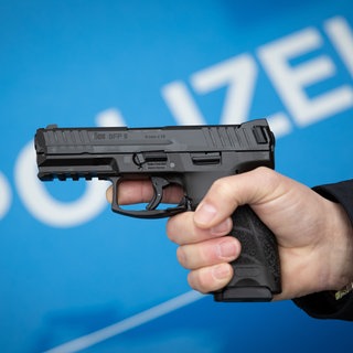 Polizist hält eine Dienstwaffe