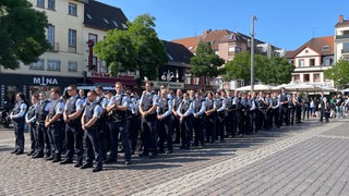 Zahlreiche Polizisten haben sich auf dem Marktplatz im Gedenken an ihren getöteten Kollegen in Reihen aufgestellt