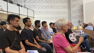 Junge Männer und andere bei einer Gedenkfeier für den getöteten Polizisten in Heidelberg