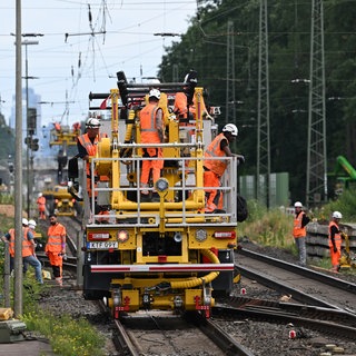 Arbeiter sind auf der Baustelle der Riedbahn mit schweren Baumaschinen im Einsatz