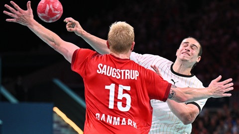 Juri Knorr kommt im Spiel um Gold bei den Olympischen Spielen gegen Dänemarks Magnus Saugstrup zum Wurf.