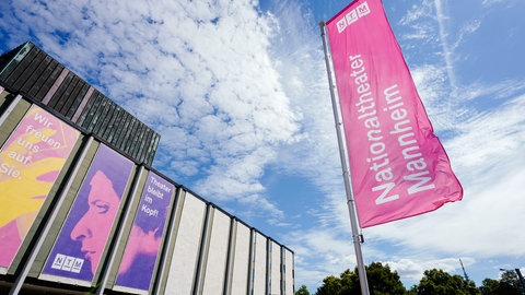 Eine bunte Fahne weht auf dem Vorplatz des Nationaltheaters Mannheim.
