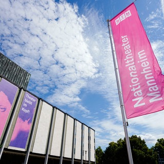 Eine bunte Fahne weht auf dem Vorplatz des Nationaltheaters Mannheim.
