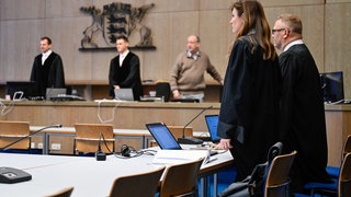 Zwei Rechtsanwälte stehen im Gerichtssaal des Mannheimer Landgerichts. 