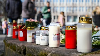 Menschen legen am Paradeplatz Blumen und Kerzen nieder.