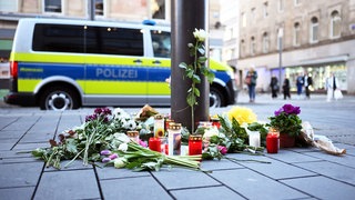 Kerzen und Blumen liegen in der Nähe des Paradeplatzes an einer Strassenbahn-Haltestelle. Am 3. März war ein Auto in eine Menschenmenge gefahren. Zwei Menschen starben, weitere wurden verletzt.