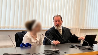 Prozessauftakt am Landgericht Heidelberg: Die Beschuldigte unterhält sich mit ihrem Verteidiger.