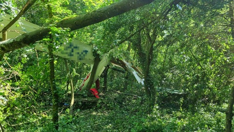 Das abgestürzte Flugzeug hängt zwischen den Bäumen.