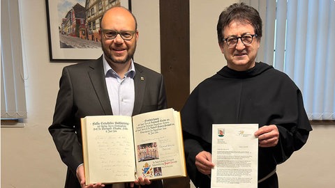 Der Brief an Papst Leo XIV. und das Goldene Buch der Stadt Walldürn. Bürgermeister Meikel Dörr (links), Pater Bregula