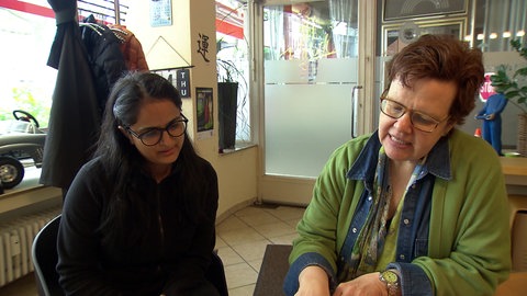 Zwei Frauen schauen in ein Notizheft