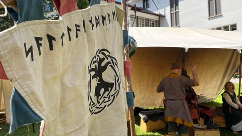 Mittelalterliche Flagge vor einem Mittelalterzelt am Innenhof der Universität